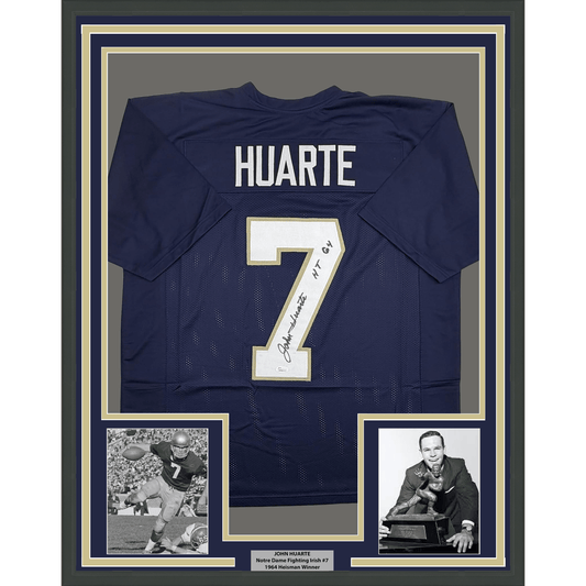 Navy blue college football jersey #7 signed by John Huarte, displayed in frame with two black-and-white photographs and nameplate.