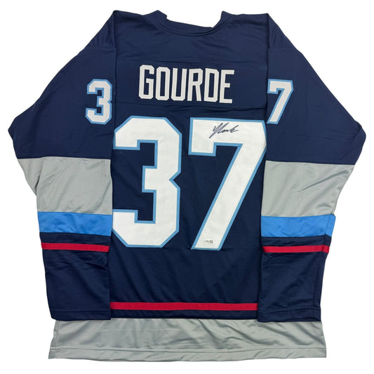 Back view of navy blue hockey jersey with "GOURDE" and number 37 printed across shoulders, featuring grey and blue striped sleeves with red accent stripe and a handwritten signature on the chest number.