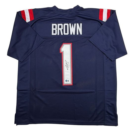 Back view of navy blue Patriots football jersey number 1 with "BROWN" nameplate and autographed number panel.