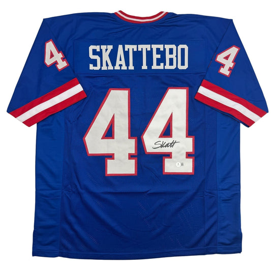 Back view of blue retro football jersey displaying "SKATTEBO" and number 44 with red and white trim and signature.