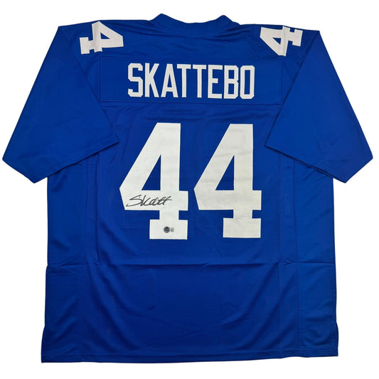 Back view of blue football jersey with white "SKATTEBO" nameplate and number 44, featuring an autographed signature on the number.