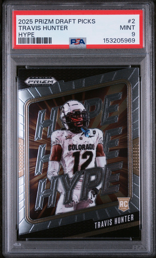 Front of graded trading card in clear PSA case showing Travis Hunter in white Colorado uniform #12 with red helmet, PSA label visible at top.