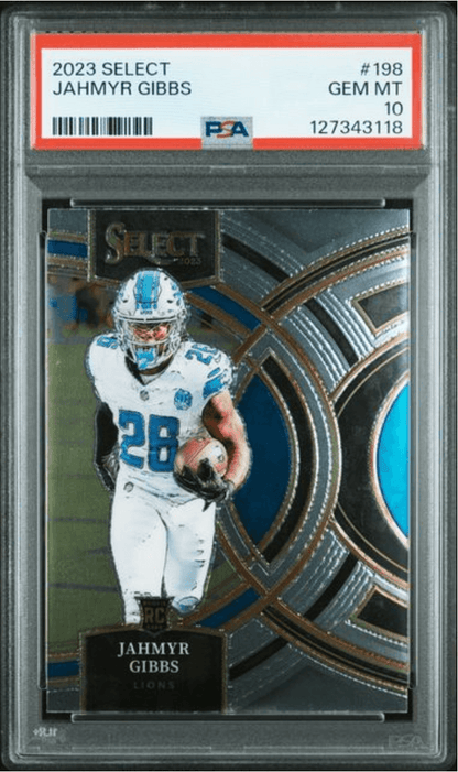 Front view of a graded card slab showing a Lions player in a white jersey with blue number 28, holding a football.