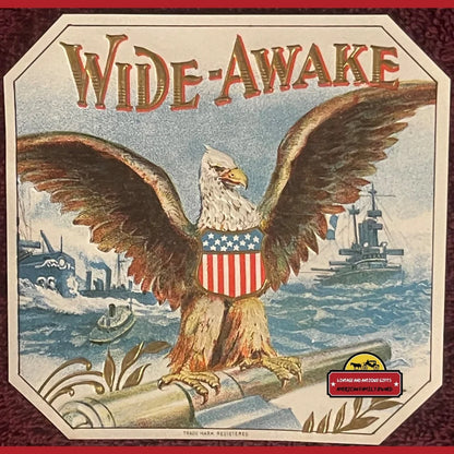 Bald eagle with wings spread, wearing American flag shield on 1910s antique cigar label