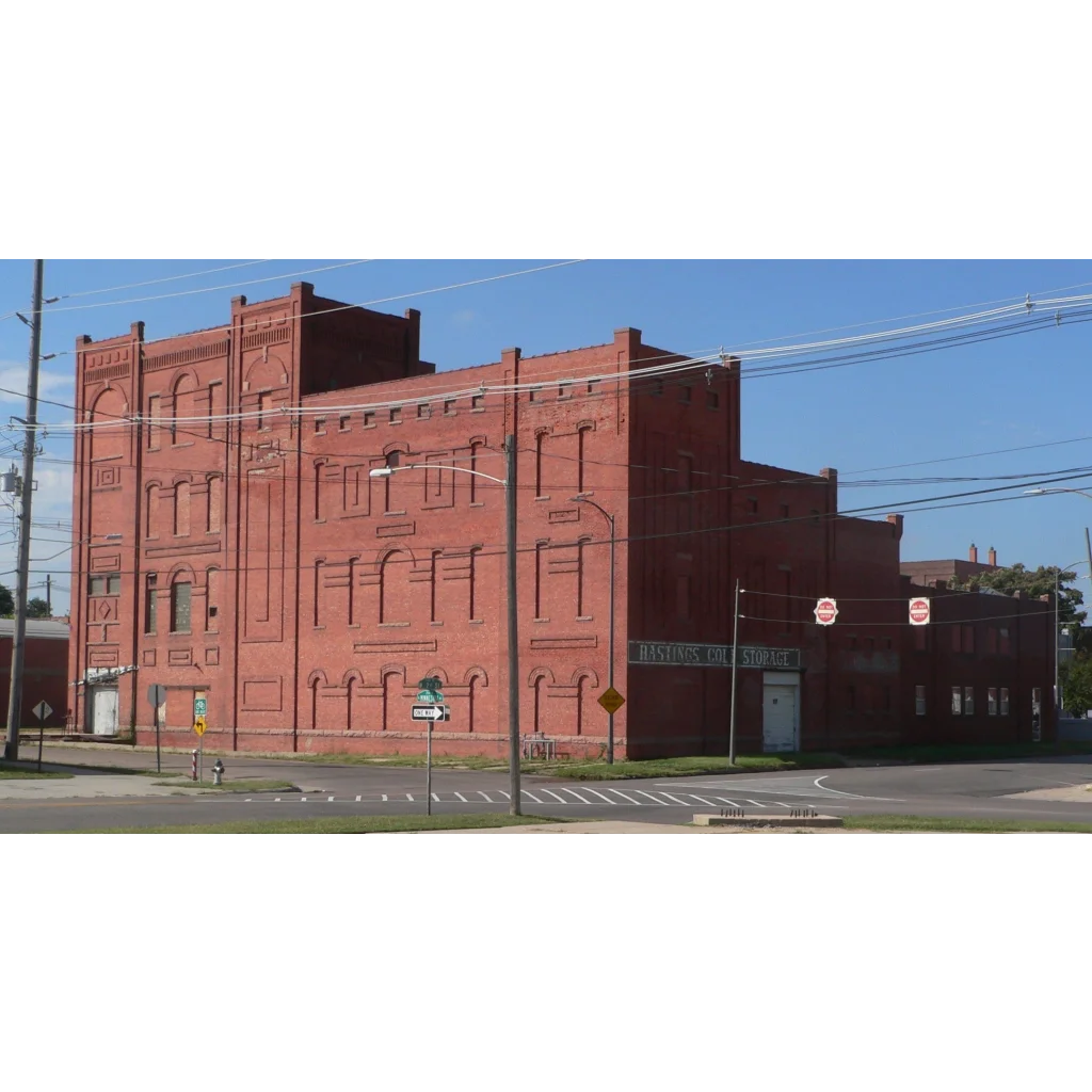 Red brick building with arched windows and decorative cornices featuring countrymaid sausage sign vintage collectible items