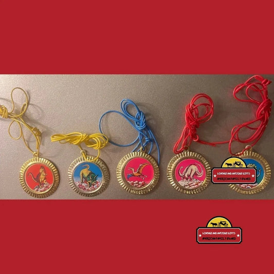 Colorful cartoon character medals on vintage tin dinosaur charms from the 1980s