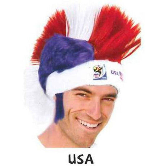 Man wearing red, white, and blue mohawk wig with USA headband, smiling at camera against white background.