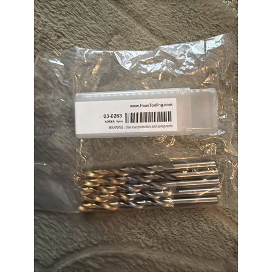 Packaged set of gold-coated metal drill bits with Haas Tooling label and barcode visible through clear plastic wrapping.