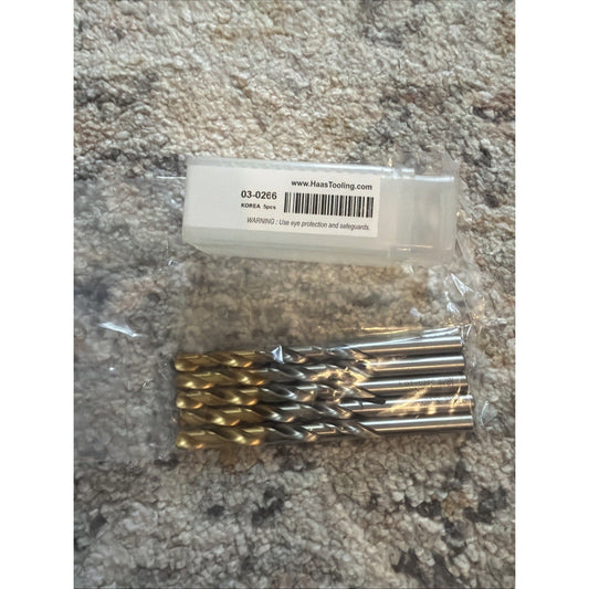 Packaged set of five gold and black titanium-coated drill bits with product label showing item number 03-0266 and www.HaasTooling.com website on textured surface.
