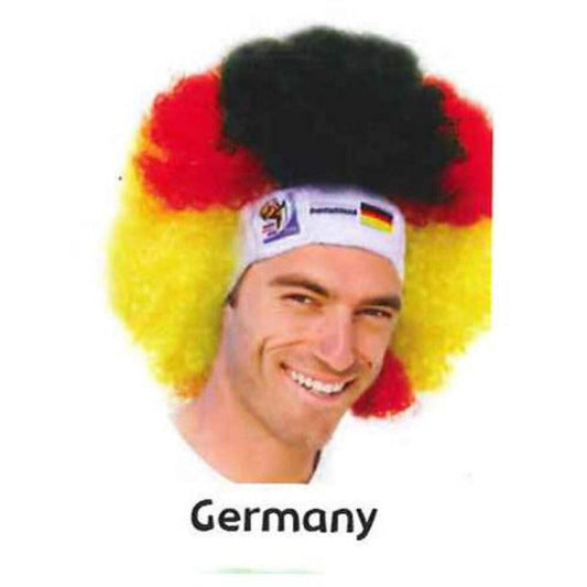 Man wearing German flag-colored afro wig with black top and white headband featuring German flag, smiling at camera.