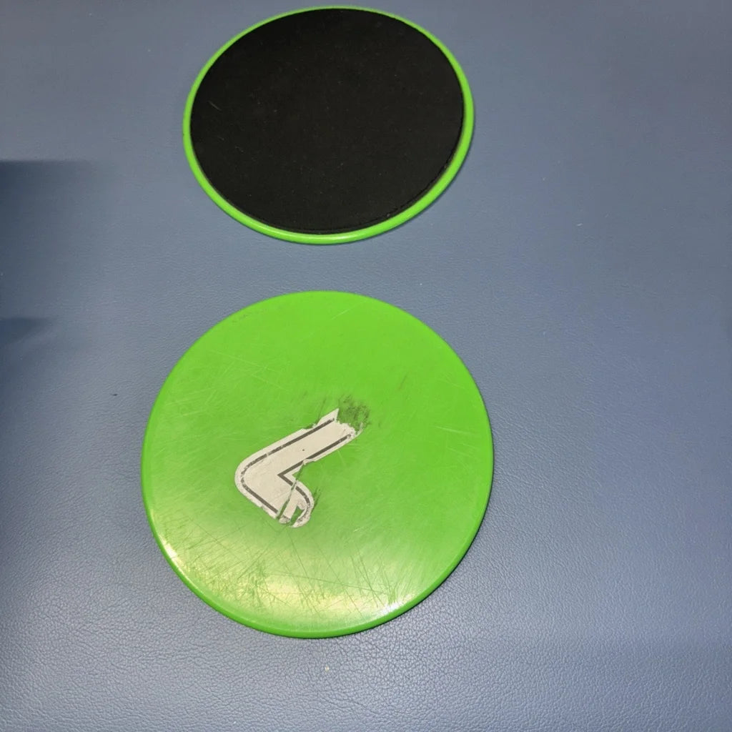 Bright green exercise sliders disc with black underside and white logo