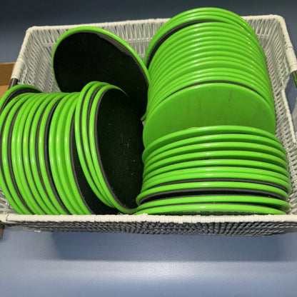 Stack of 43 bright green exercise sliders in white basket