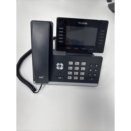 Yealink T54W IP phone displayed from above on white surface, showing handset with coiled cord, numeric keypad, navigation dial, and dark touchscreen display.