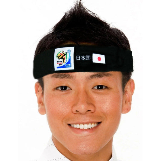 Person wearing black fabric headband with 2010 South Africa FIFA World Cup logo, Japanese text, and Japanese flag printed on front.