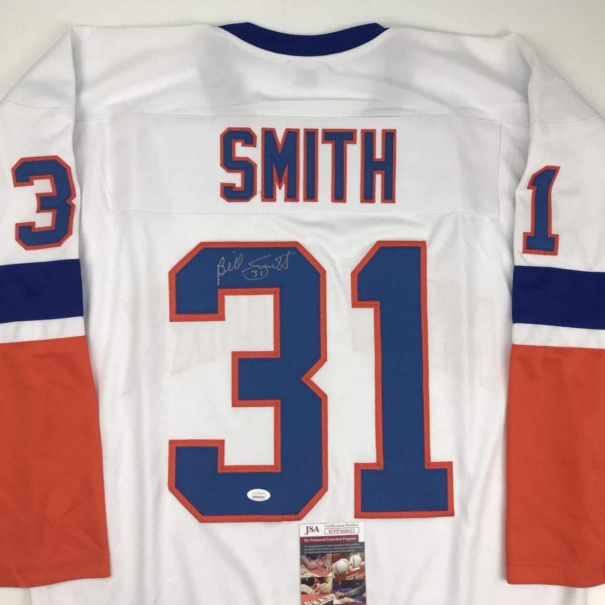 Back view of white hockey jersey with "SMITH" and number 31 in blue and red, signed in blue ink, with JSA authentication certificate visible at bottom.