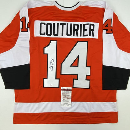Flat lay of signed orange, white, and black Philadelphia Flyers hockey jersey number 14 with Couturier nameplate and JSA authentication certificate.