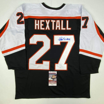 Black Philadelphia Flyers hockey jersey number 27 with "HEXTALL" name and blue autograph, displayed flat with JSA authentication certificate.