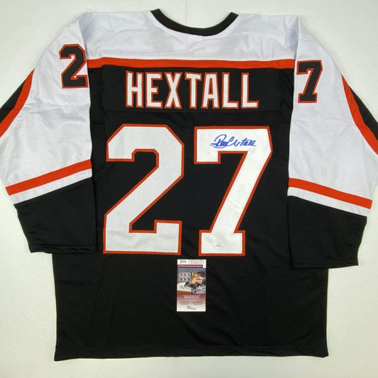Black Philadelphia Flyers hockey jersey number 27 with "HEXTALL" name and blue autograph, displayed flat with JSA authentication certificate.