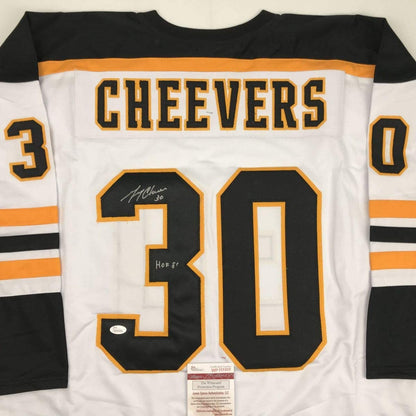 Back view of white Boston Cheevers hockey jersey number 30 with black and orange trim, signed with JSA authentication label visible.