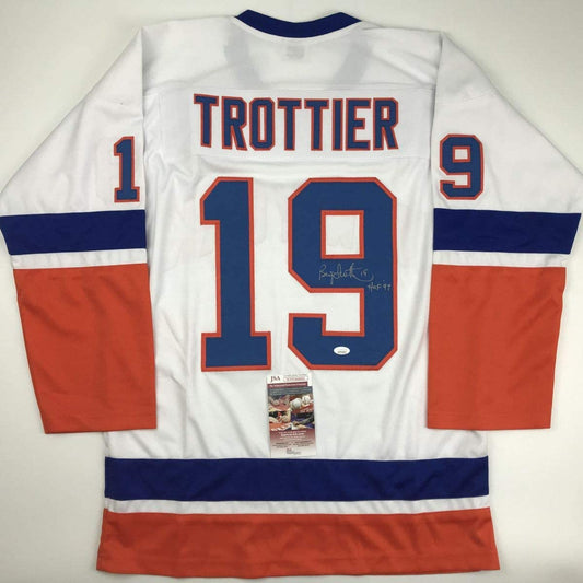 Rear view of white, navy, and red hockey jersey number 19 with "TROTTIER" nameplate and autographed inscription, displaying JSA authentication certificate.