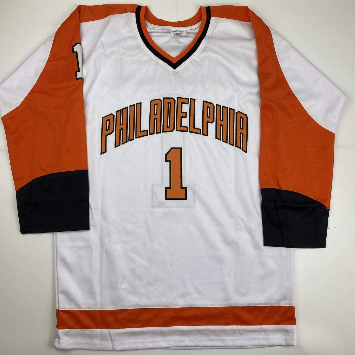 White Philadelphia hockey jersey number 1 with orange and black sleeves displayed flat against neutral background.