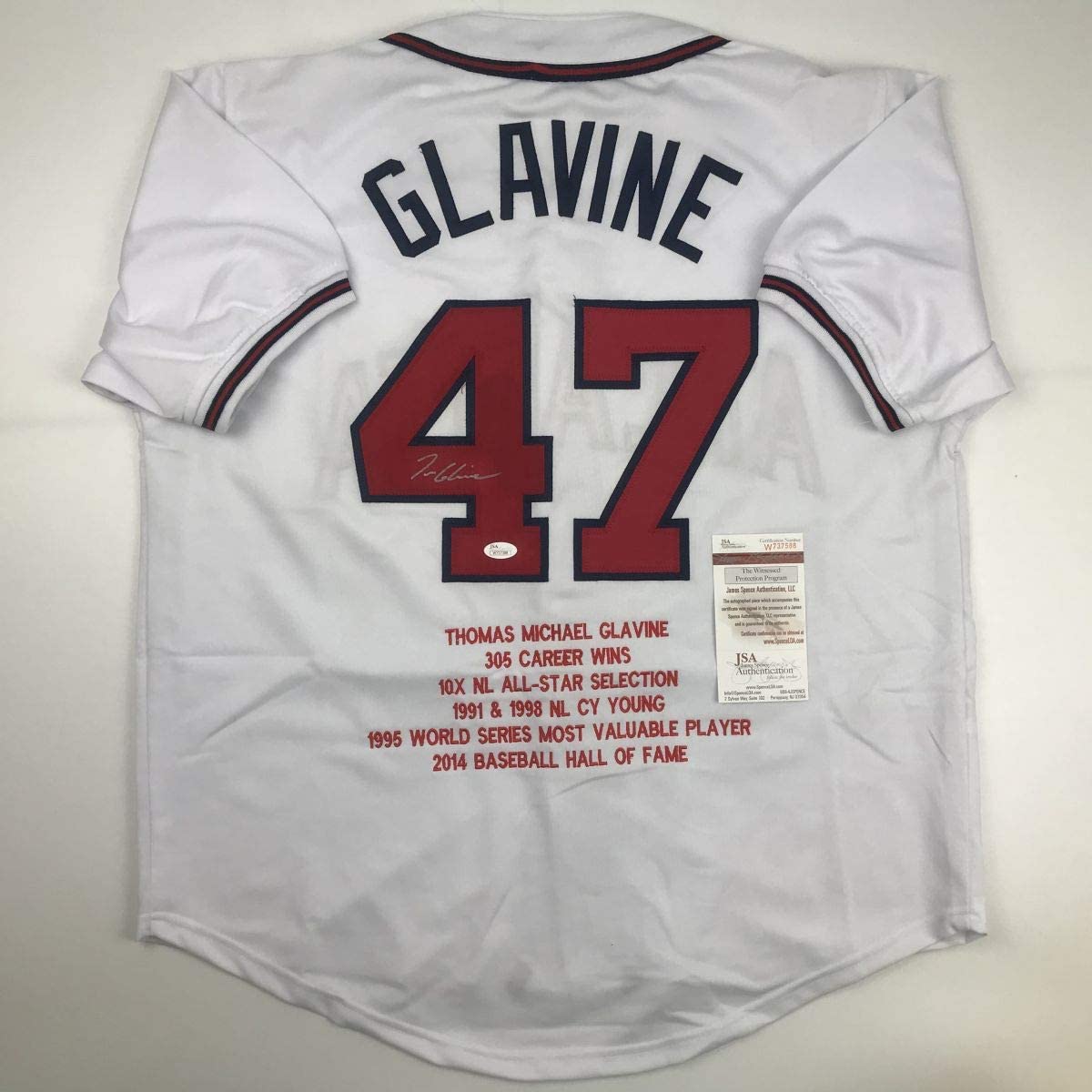 Back view of white baseball jersey number 47 with "GLAVINE" printed across shoulders, displaying career statistics and Hall of Fame information, with JSA authentication certificate visible.
