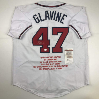 Back view of white baseball jersey number 47 with "GLAVINE" printed across shoulders, displaying career statistics and Hall of Fame information, with JSA authentication certificate visible.