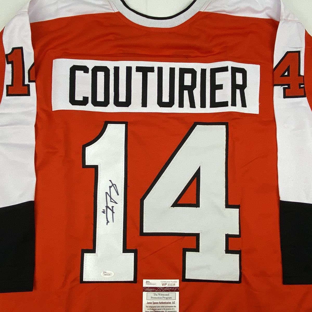 Front view of signed orange Philadelphia Flyers hockey jersey number 14 with "COUTURIER" nameplate and JSA authentication label.