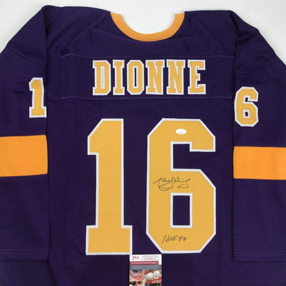 Purple Los Angeles Dionne hockey jersey number 16 with gold and white lettering, displayed flat showing front with signature and JSA authentication certificate.
