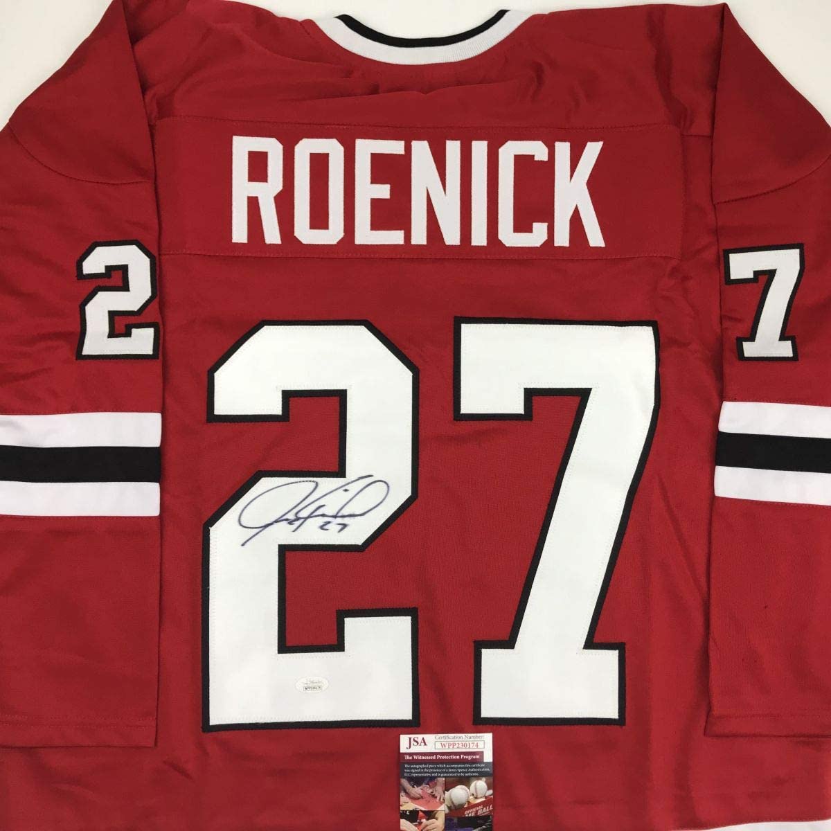 Back view of red hockey jersey with "ROENICK" and number 27 in white and black lettering, signed in blue ink, with JSA authentication label.
