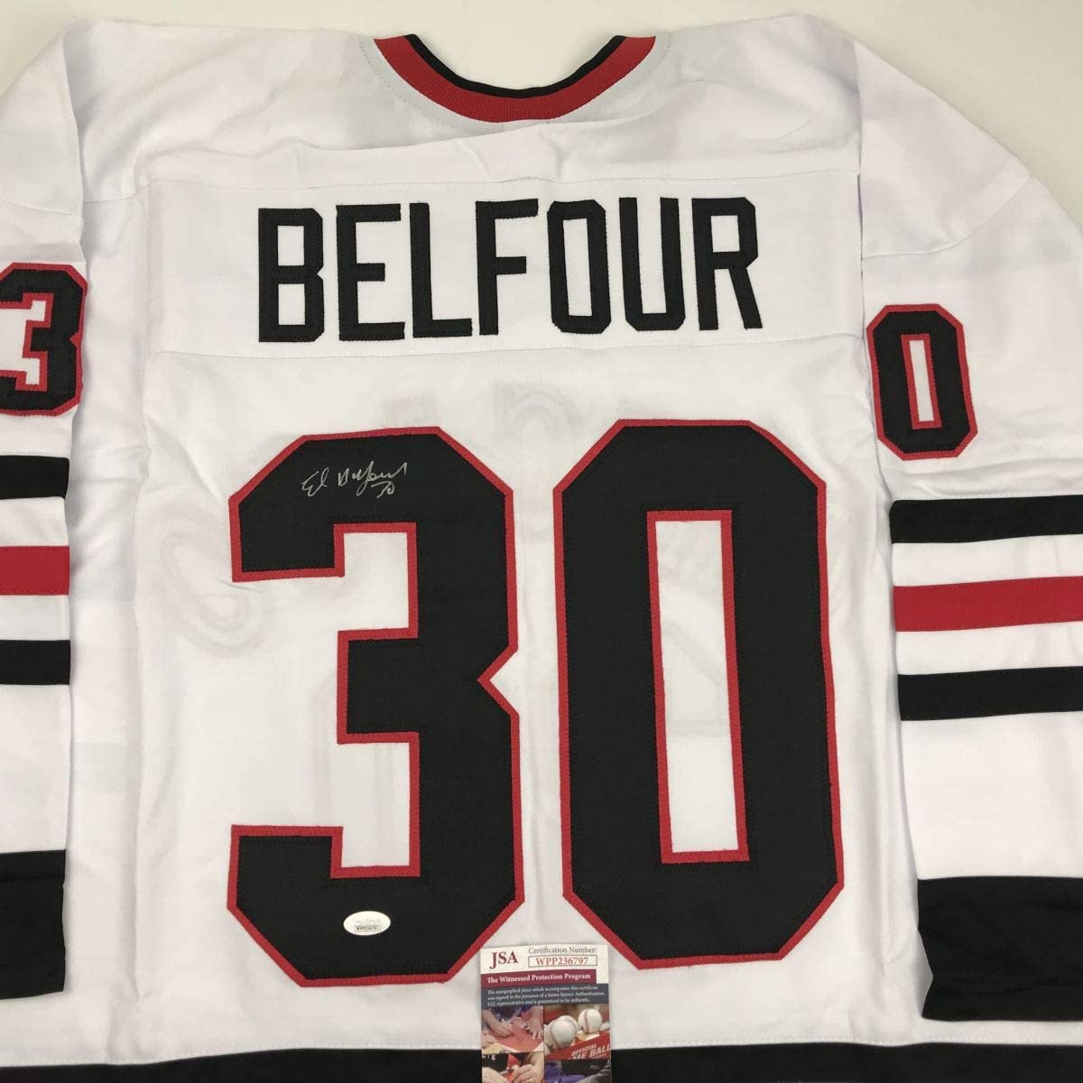 White hockey jersey with "BELFOUR" and number 30 displayed, showing JSA authentication certificate and signature detail.