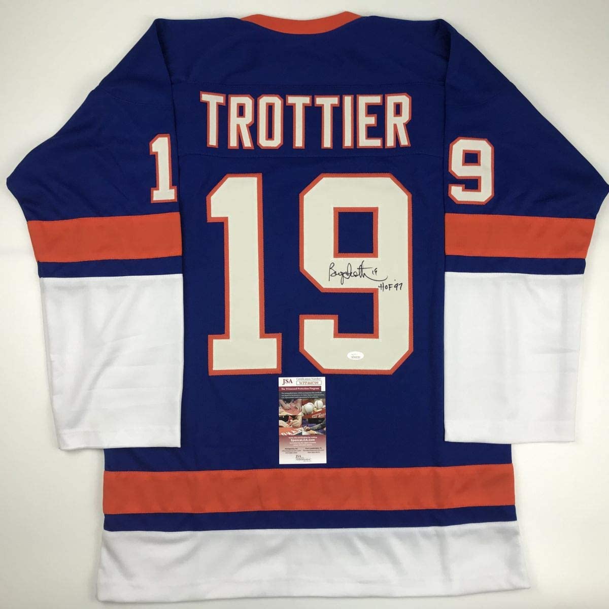 Back view of signed blue, orange, and white Trottier #19 hockey jersey with JSA authentication certificate visible.
