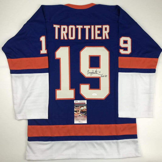 Back view of signed blue, orange, and white Trottier #19 hockey jersey with JSA authentication certificate visible.