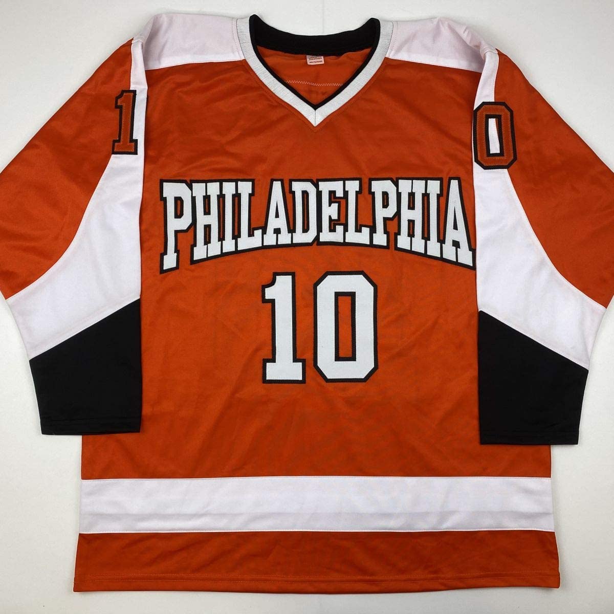 Philadelphia Flyers orange hockey jersey number 10 laid flat, displaying front with white and black trim, showing "PHILADELPHIA" text and jersey number.