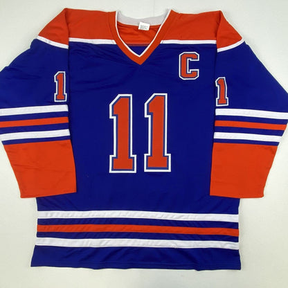 Blue Edmonton Oilers hockey jersey with red and white stripes, number 11 in red, displayed flat against white background.