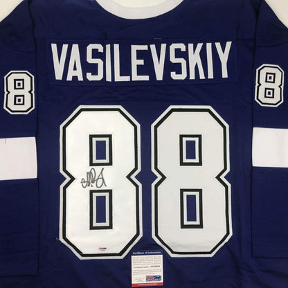 Front view of navy blue hockey jersey with "VASILEVSKIY" and number 88 in white, featuring autograph on left chest number and PSA/DNA authenticity certificate.