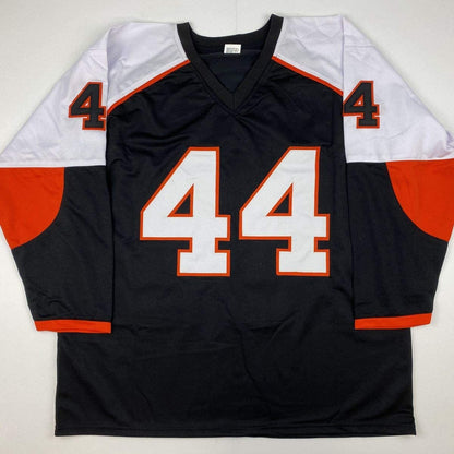 Black, orange, and white hockey jersey number 44 displayed flat against white background, front view showing V-neck collar and color-block sleeves.