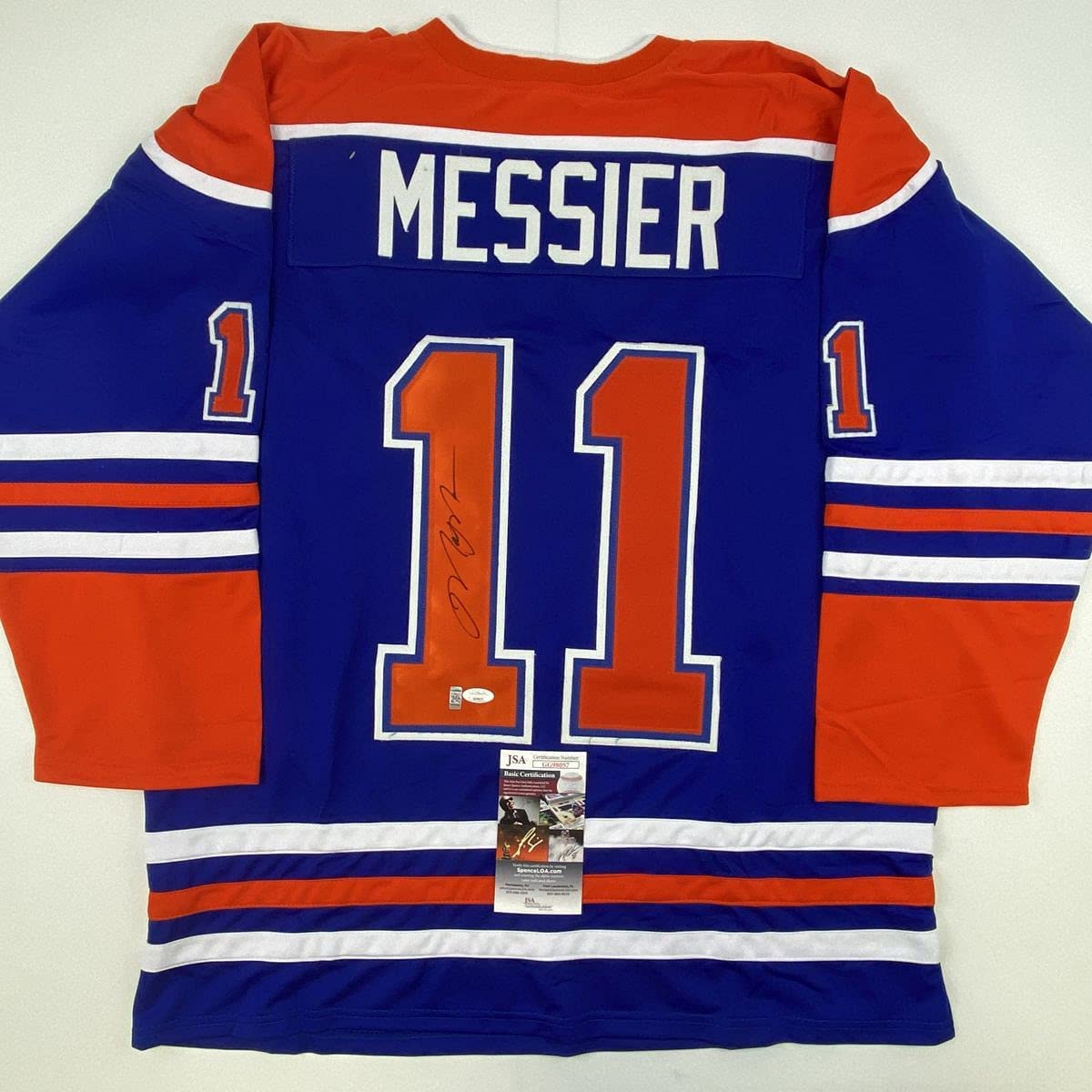 Blue and orange Edmonton Oilers hockey jersey with "MESSIER" and number 11, displayed flat with JSA authentication certificate visible at bottom.