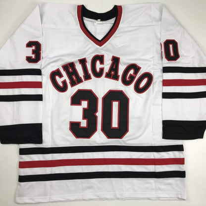 White Chicago hockey jersey with red and black striped sleeves, displaying "CHICAGO" and number 30 across the chest, laid flat against a neutral background.