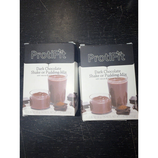 Two Protifit Dark Chocolate Shake or Pudding Mix boxes displayed side-by-side on a black scratched surface, showing product images and text.