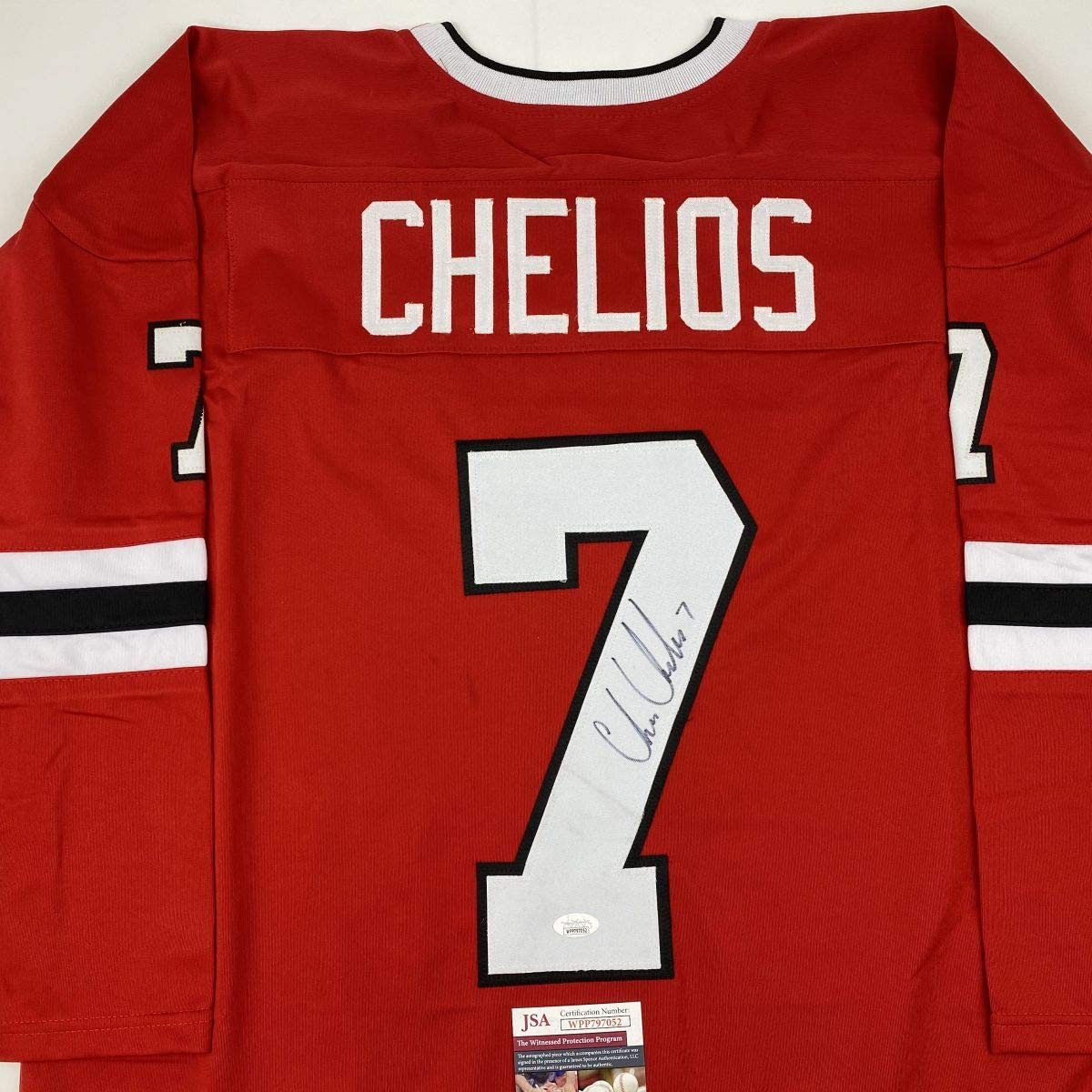Red hockey jersey displaying "CHELIOS" and number 7 with autograph and JSA authentication label, back view.