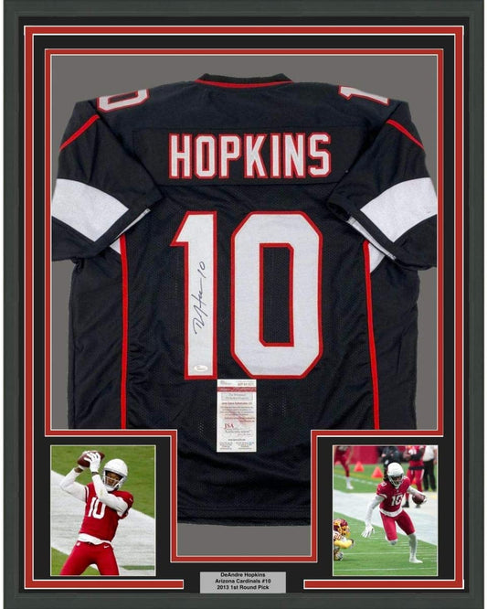 Back view of framed black Arizona Cardinals #10 football jersey signed by DeAndre Hopkins, flanked by two action photos.