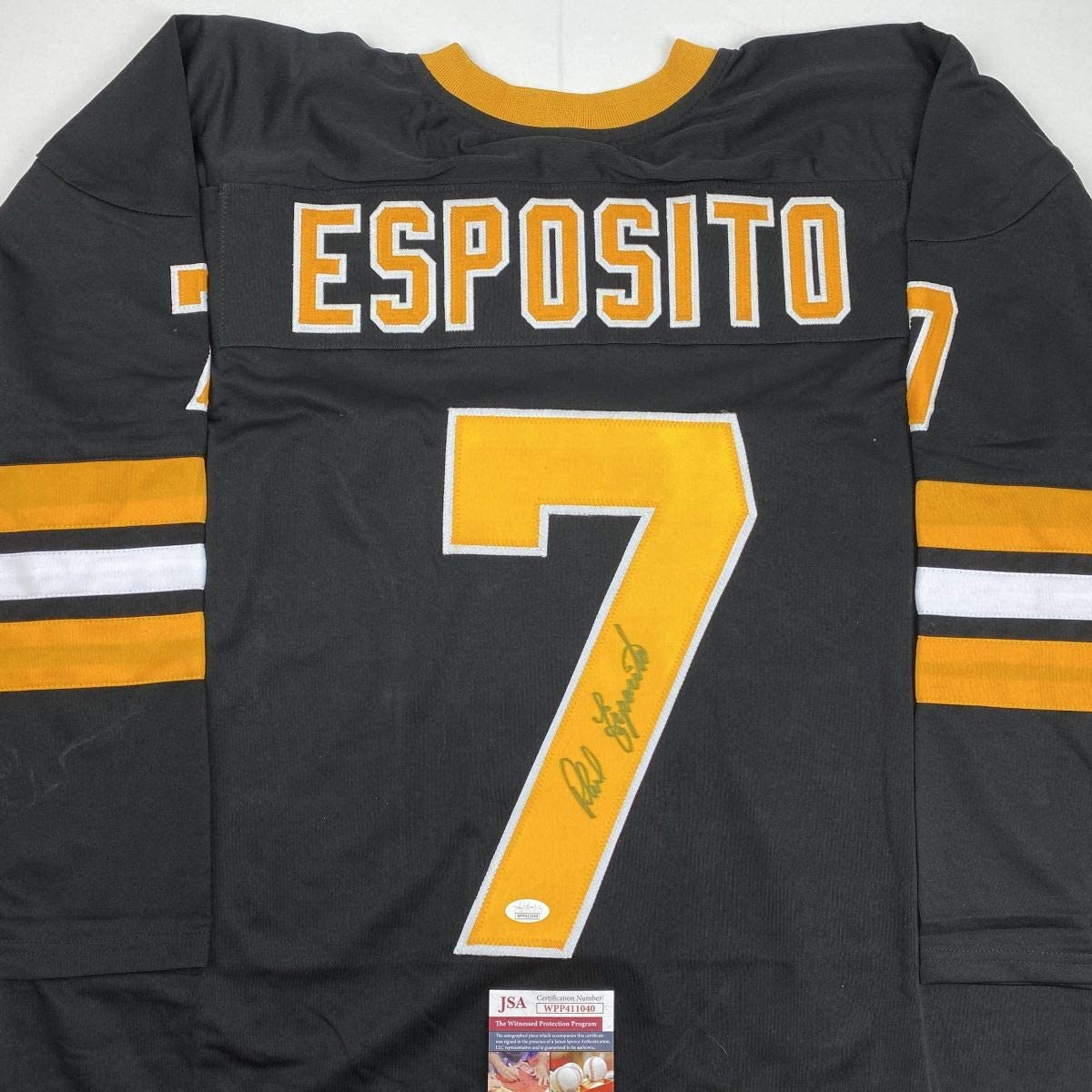 Back view of black Boston hockey jersey number 7 with "ESPOSITO" in gold and white lettering, signed in gold marker on yellow number, JSA authentication label visible at bottom.