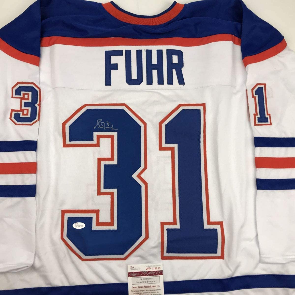Back view of white Edmonton Oilers hockey jersey number 31 with "FUHR" nameplate and JSA authentication label.