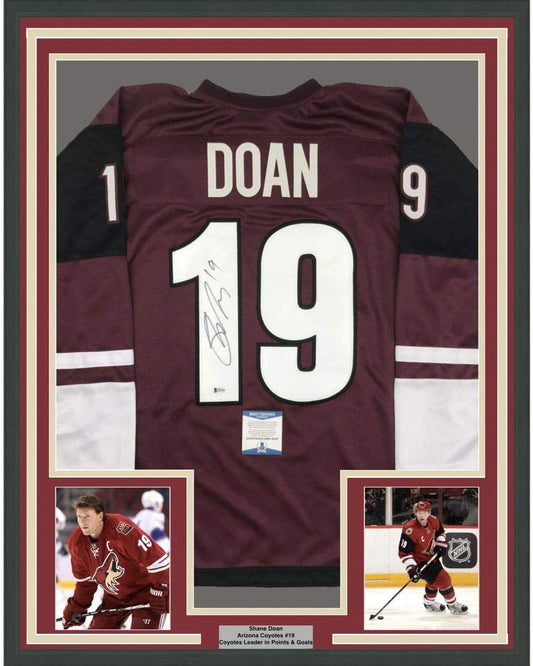 Framed maroon Arizona Coyotes jersey number 19 signed by Shane Doan, displayed with two action photos and authentication certificate.