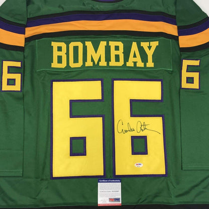 Front view of green Bombay hockey jersey number 55 with yellow numbers, orange stripe, and signature visible on right chest area with PSA/DNA certificate below.