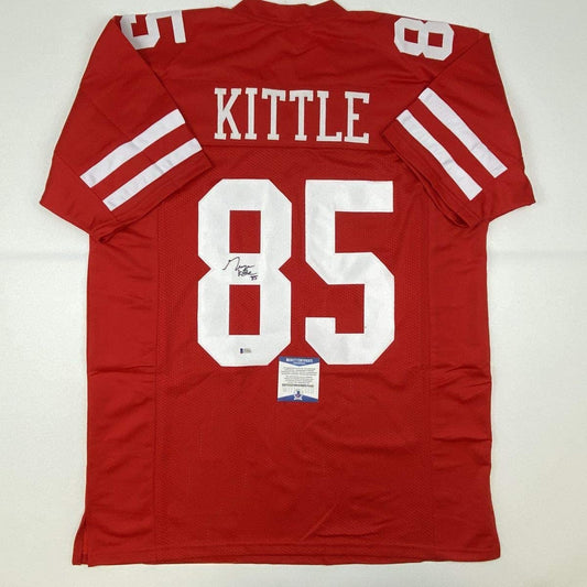Red San Francisco football jersey numbered 85 with "KITTLE" nameplate, displayed flat with signature and authentication certificate visible.