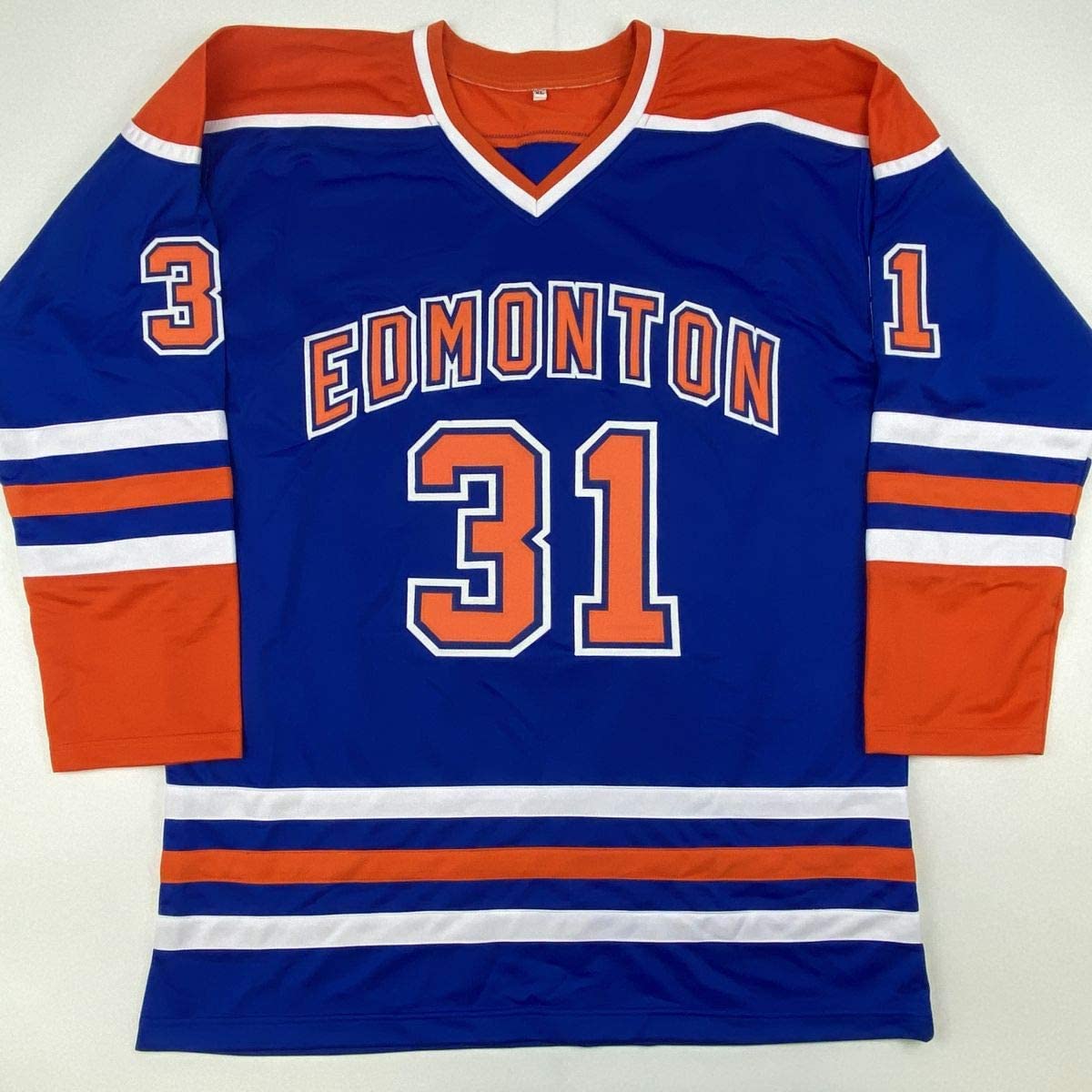 Blue Edmonton Oilers hockey jersey with orange and white stripes, displaying number 31 on chest and shoulders, laid flat against white background.