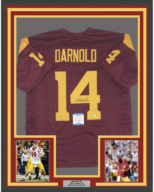 Framed maroon and gold USC football jersey number 14 signed by Sam Darnold with authentication certificate and action photos.