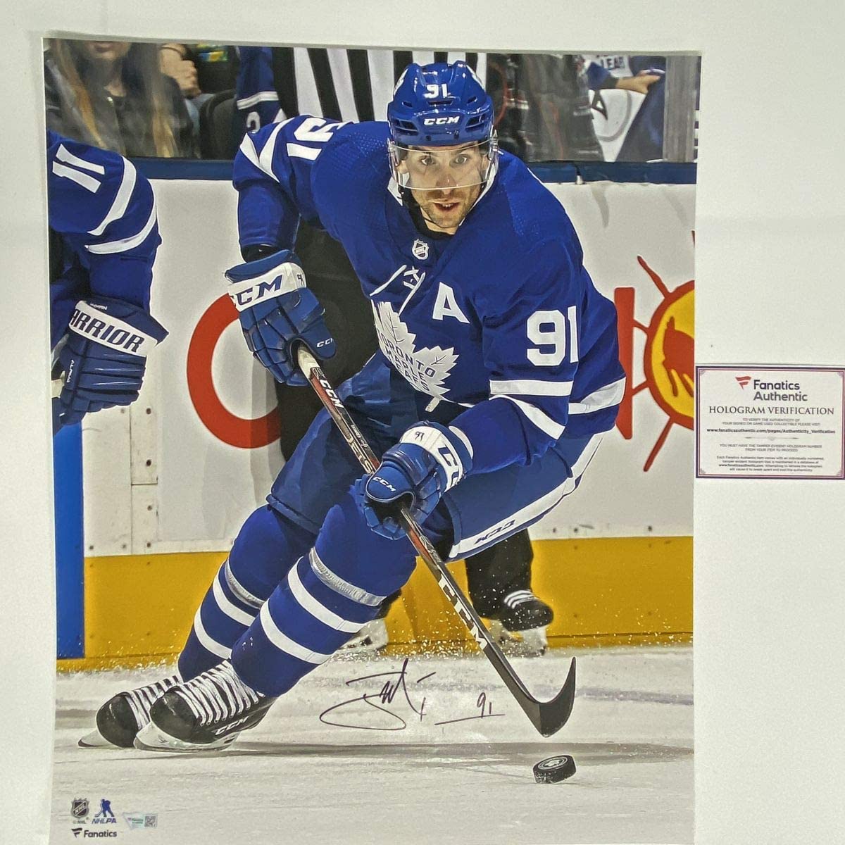 Signed John Tavares Toronto Maple Leafs 16x20 photo showing player in blue jersey number 91 skating with puck, Fanatics authentication hologram visible.